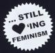 Zum tailliertes Tanktop "... still loving feminism" für 13,12 € gehen.