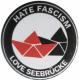 Zur Artikelseite von "Hate Fascism - Love Seebrücke", 25mm Magnet-Button für 2,00 €